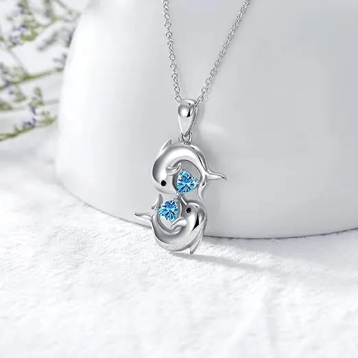 Silberne Halskette mit zwei Delfinen und blauem Kristall