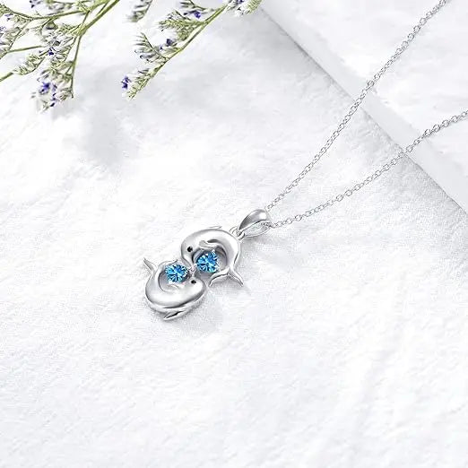 Silberne Halskette mit zwei Delfinen und blauem Kristall
