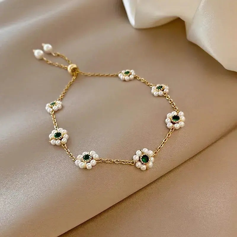 Elegantes Gänseblümchen Armband mit grünen Kristallen